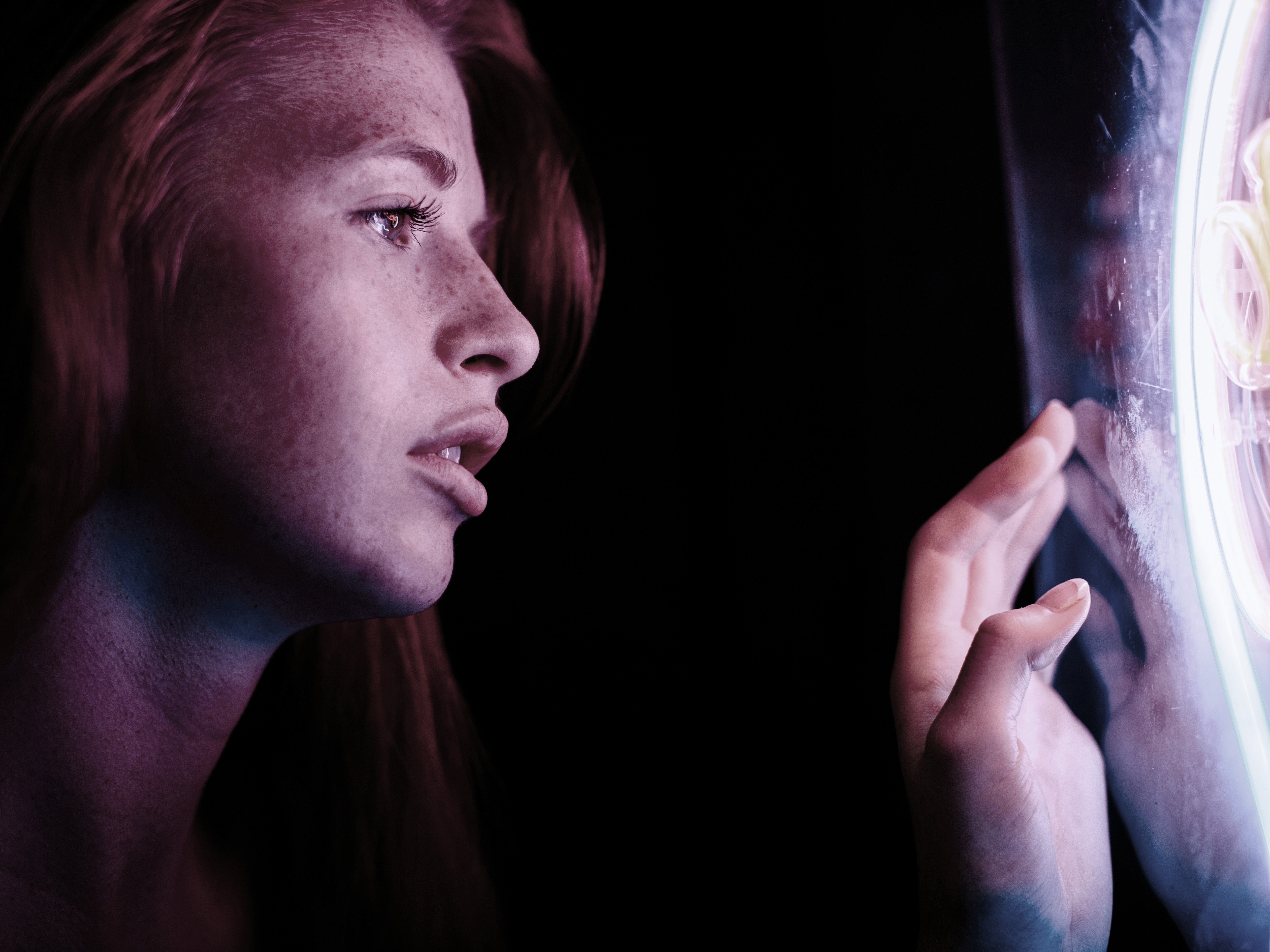 Anime Report front cover with the face of a young woman facing right looking at a screen which she is touching with her hand. The background is black